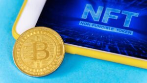 Golden Bitcoin coin on a blue background with a smartphone showing "NFT: Non-Fungible Token" on its screen.