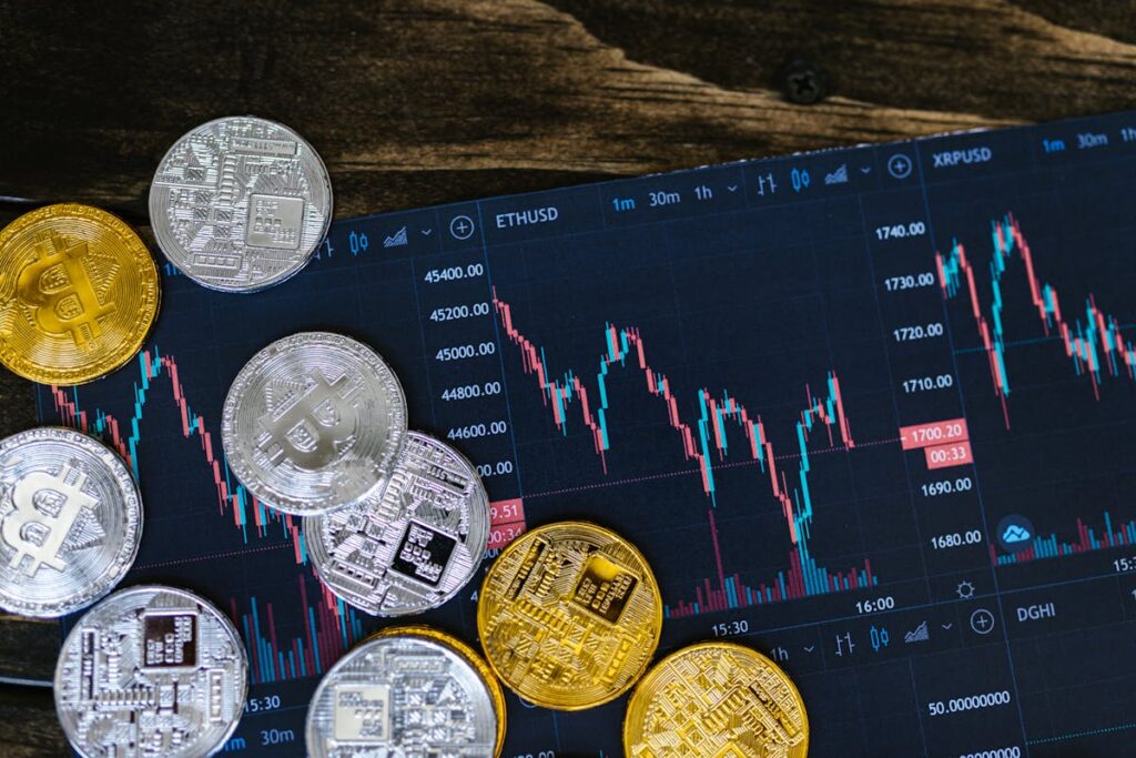Various cryptocurrency coins on a tablet displaying live trading charts of digital currency markets.