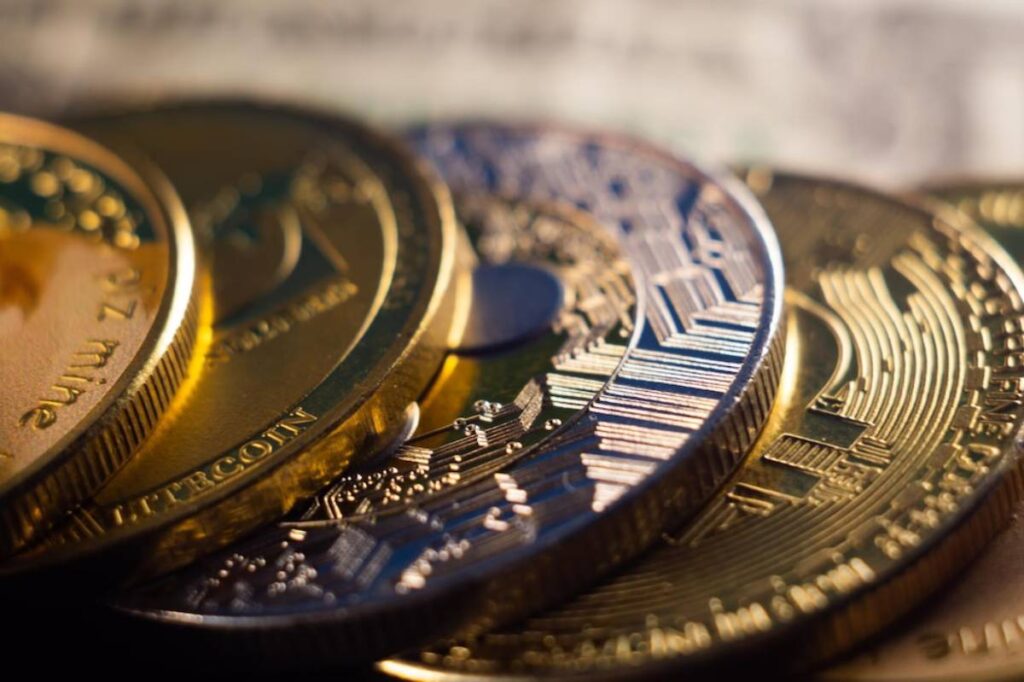 Close-up of various cryptocurrency coins including Bitcoin and Litecoin, emphasizing their intricate designs and metallic textures.
