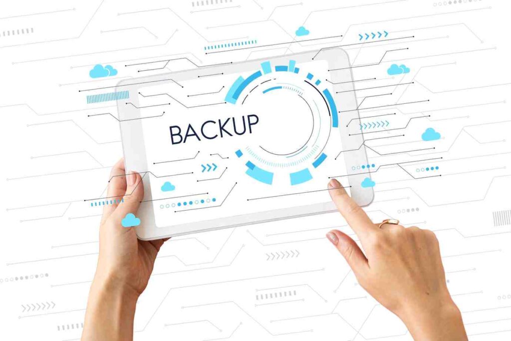 A person interacts with a tablet displaying the word backup