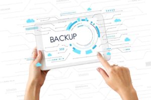 A person interacts with a tablet displaying the word backup